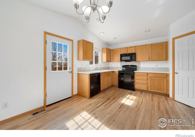 kitchen with visible vents, a sink, black appliances, light countertops, and a chandelier