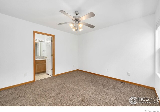 unfurnished room with visible vents, light colored carpet, a ceiling fan, and baseboards