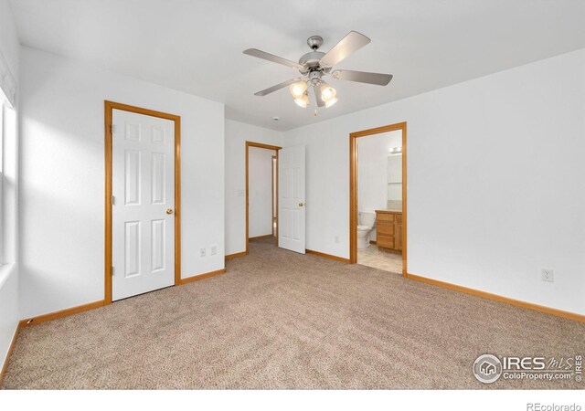 unfurnished bedroom featuring ensuite bath, baseboards, and carpet floors