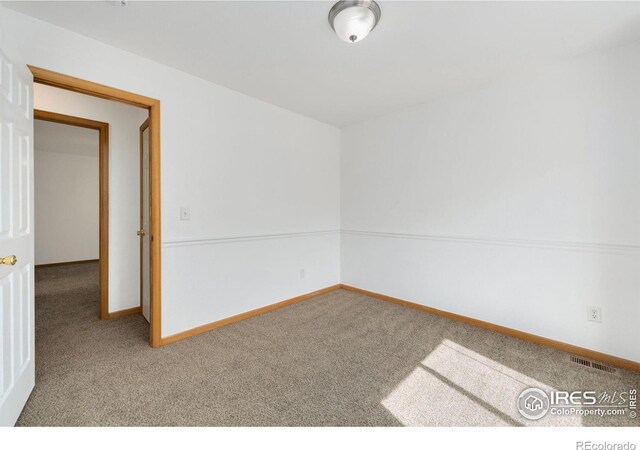 unfurnished room with baseboards, visible vents, and carpet floors