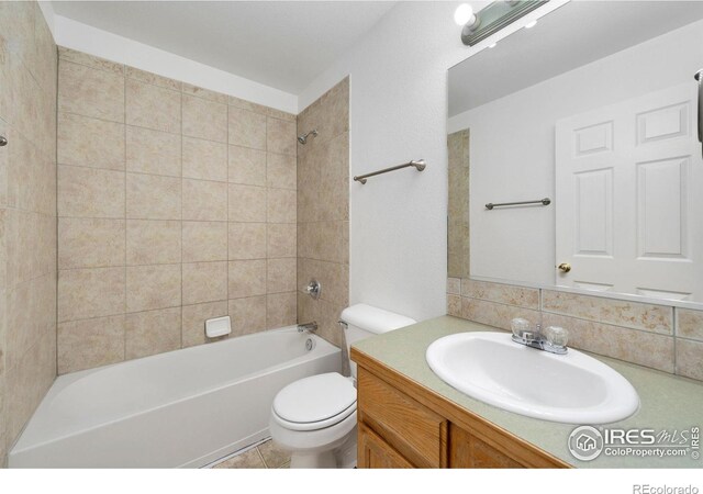 bathroom with backsplash, vanity, toilet, and  shower combination