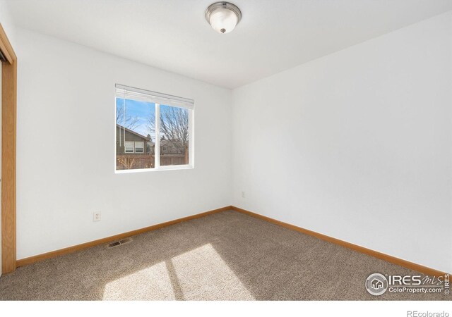 carpeted empty room with visible vents and baseboards