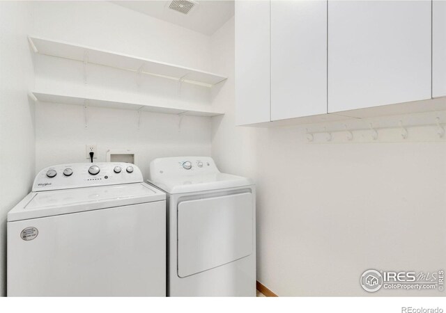 laundry area featuring washer and dryer, cabinet space, and visible vents