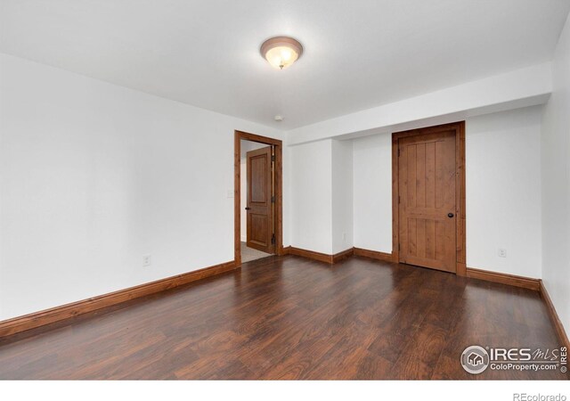 unfurnished room featuring baseboards and wood finished floors