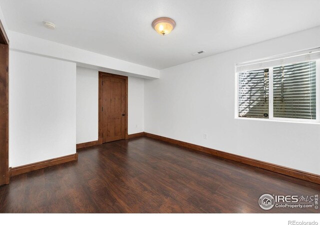 empty room with visible vents, baseboards, and wood finished floors