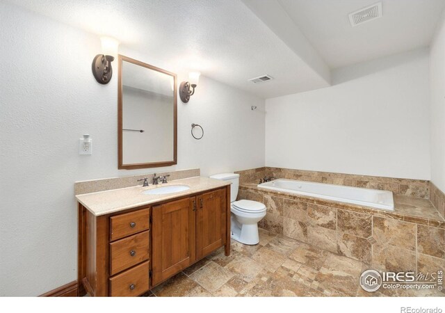 bathroom featuring visible vents, toilet, a bath, and vanity