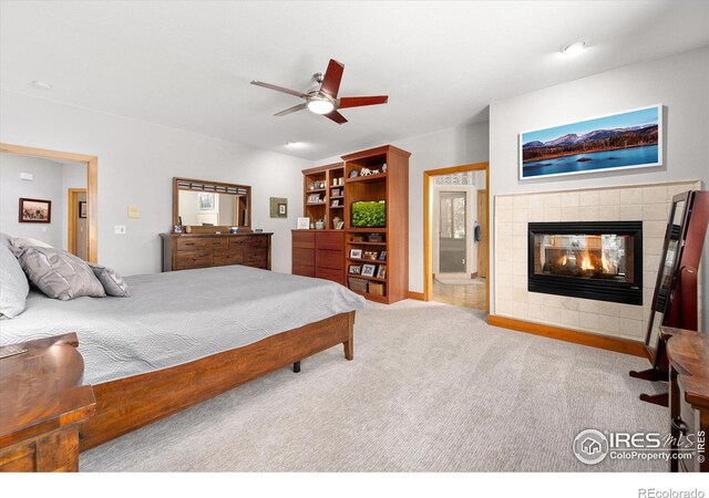 carpeted bedroom with a ceiling fan and a fireplace