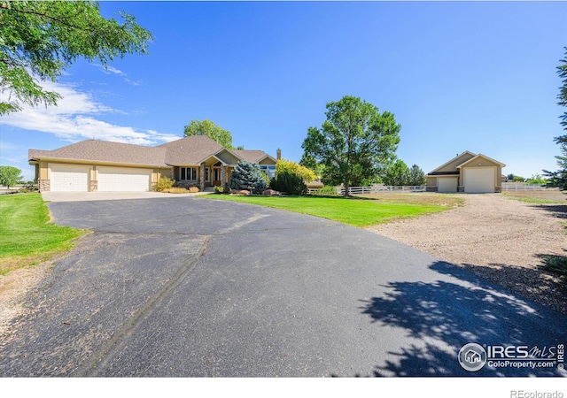 single story home featuring an attached garage, fence, driveway, and a front lawn