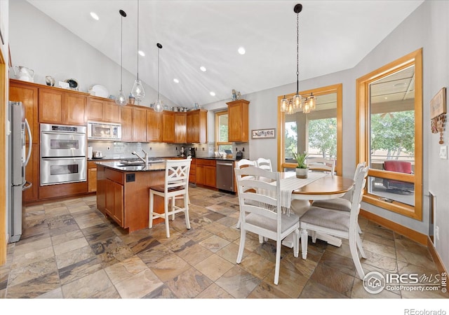 39658 Ridge Park Dr, Severance, CO 80610 - kitchen featuring stainless steel appliances, stone tile flooring, vaulted ceiling, a chandelier, and brown cabinets