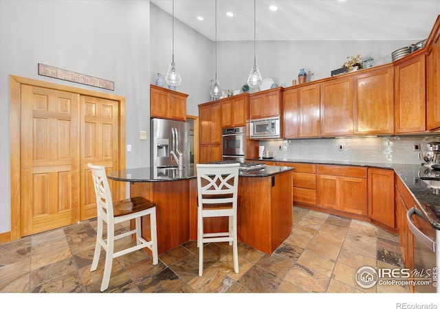 39658 Ridge Park Dr, Severance, CO 80610 - kitchen with stainless steel appliances, high vaulted ceiling, stone tile flooring, tasteful backsplash, and an island with sink