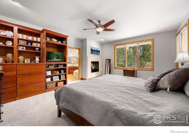 39658 Ridge Park Dr, Severance, CO 80610 - bedroom with a tile fireplace, ceiling fan, and ensuite bathroom