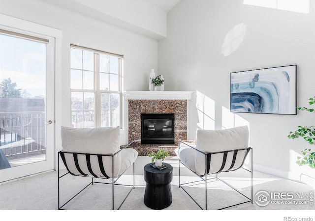 carpeted living room with a premium fireplace and baseboards