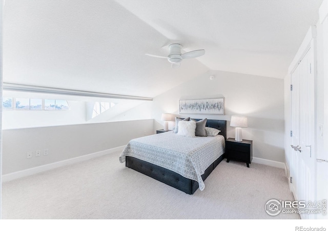 carpeted bedroom with a ceiling fan, vaulted ceiling, and baseboards