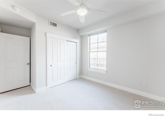 unfurnished bedroom featuring carpet floors, baseboards, visible vents, and a closet