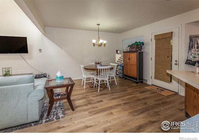 dining area featuring wood finished floors and a notable chandelier