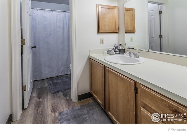 bathroom featuring curtained shower, wood finished floors, and vanity