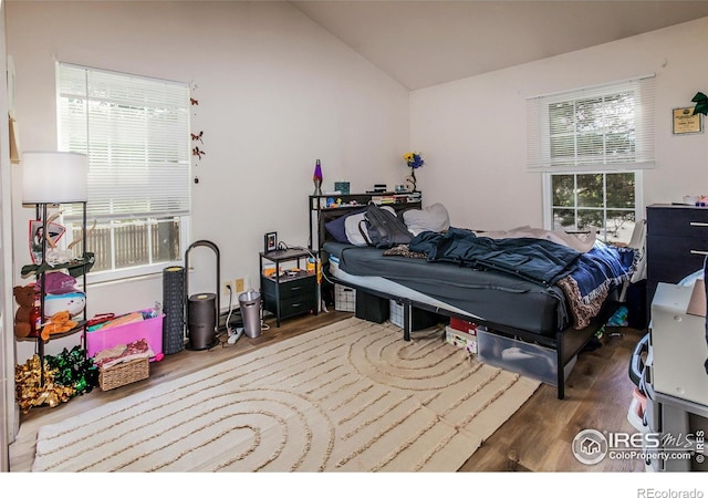 bedroom with vaulted ceiling and wood finished floors