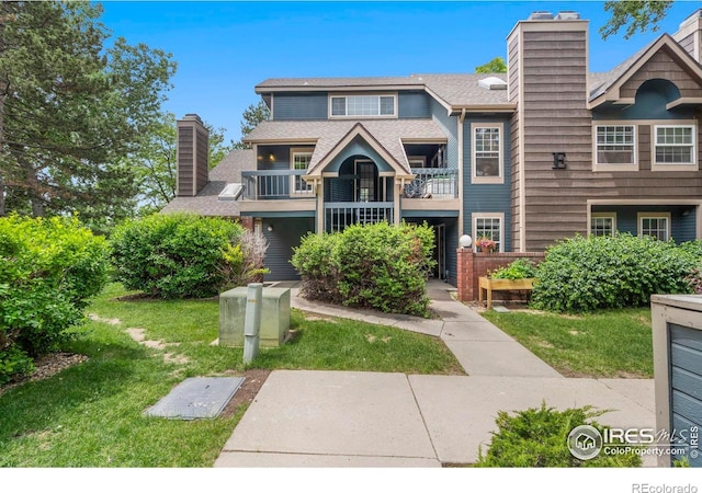 3565 Windmill Dr Unit 5, Fort Collins, CO 80526 - view of front of house with a chimney, a balcony, a front lawn, and roof with shingles