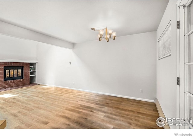 3565 Windmill Dr Unit 5, Fort Collins, CO 80526 - unfurnished living room with light wood-type flooring, a chandelier, baseboards, and a fireplace
