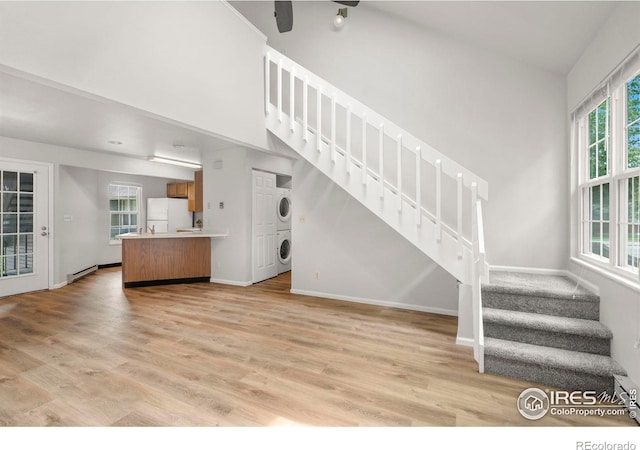3565 Windmill Dr Unit 5, Fort Collins, CO 80526 - unfurnished living room with stacked washer / drying machine, stairway, and light wood-style flooring