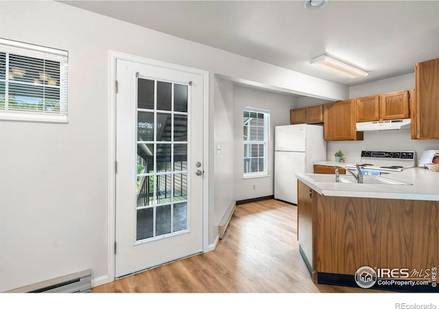 3565 Windmill Dr Unit 5, Fort Collins, CO 80526 - kitchen with under cabinet range hood, white appliances, a baseboard radiator, brown cabinetry, and light wood-style flooring