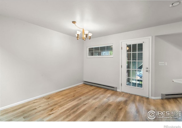 3565 Windmill Dr Unit 5, Fort Collins, CO 80526 - unfurnished dining area with baseboard heating, a chandelier, wood finished floors, and healthy amount of natural light