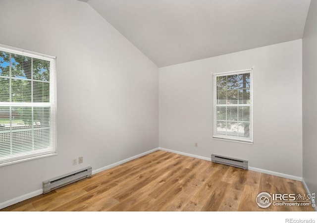 3565 Windmill Dr Unit 5, Fort Collins, CO 80526 - empty room with a baseboard radiator, vaulted ceiling, light wood-style floors, and baseboards