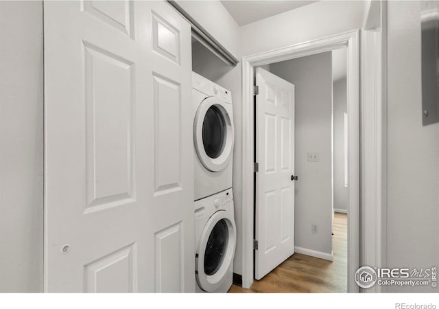 3565 Windmill Dr Unit 5, Fort Collins, CO 80526 - washroom featuring stacked washer and clothes dryer, wood finished floors, and baseboards