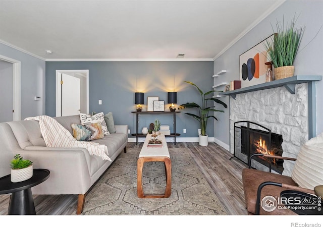 living area with visible vents, a fireplace, ornamental molding, and wood finished floors