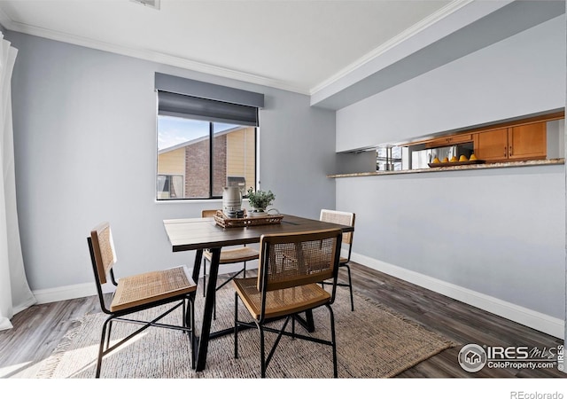 dining area with crown molding, baseboards, and wood finished floors