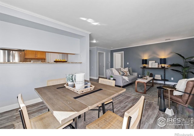 dining area with crown molding, baseboards, and wood finished floors