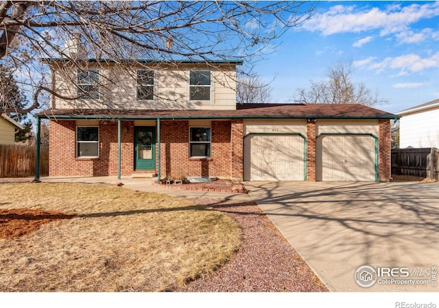 traditional-style house featuring concrete driveway, brick siding, fence, and an attached garage