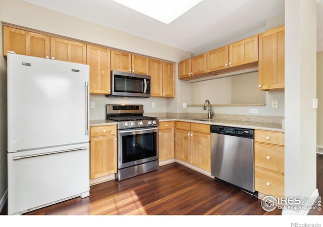 kitchen featuring dark wood-style floors, stainless steel appliances, a sink, and light brown cabinets