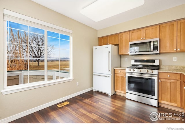 kitchen with stainless steel appliances, dark wood finished floors, visible vents, and baseboards