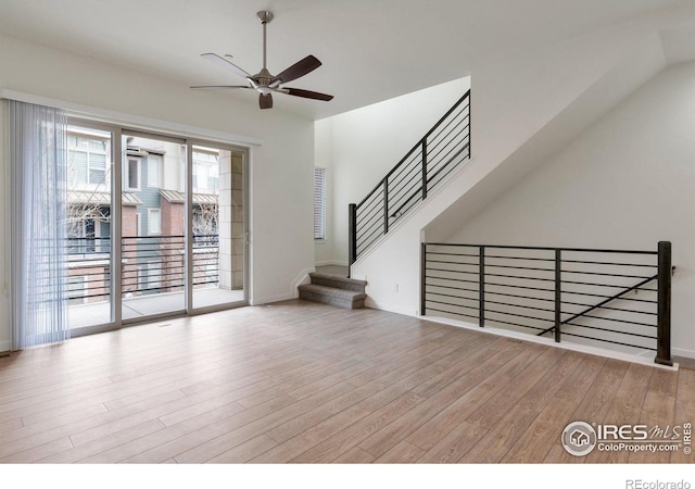 unfurnished living room with ceiling fan, baseboards, and wood finished floors