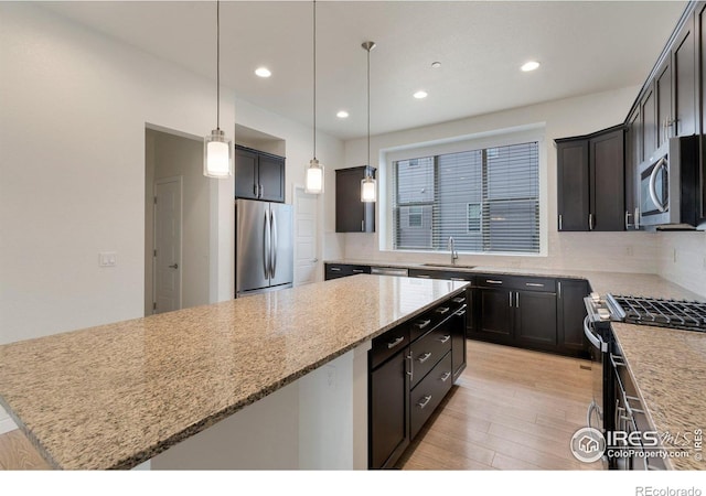 kitchen with appliances with stainless steel finishes, a center island, a sink, and backsplash