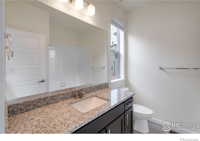 full bath featuring vanity, toilet, and baseboards