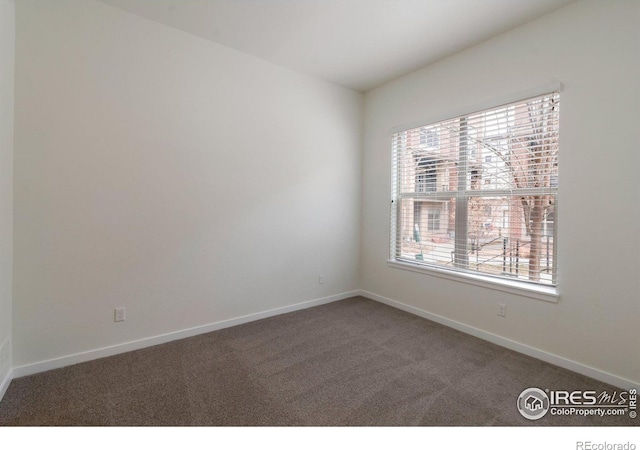 carpeted spare room with baseboards