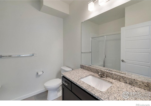 bathroom with toilet, a shower with shower door, vanity, tile patterned flooring, and baseboards