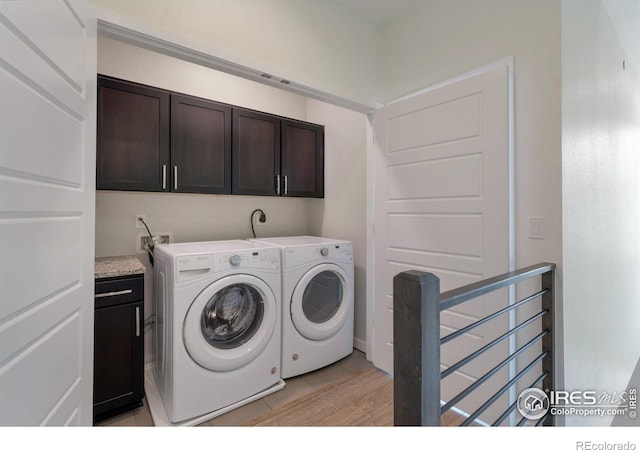 clothes washing area featuring cabinet space and washer and dryer