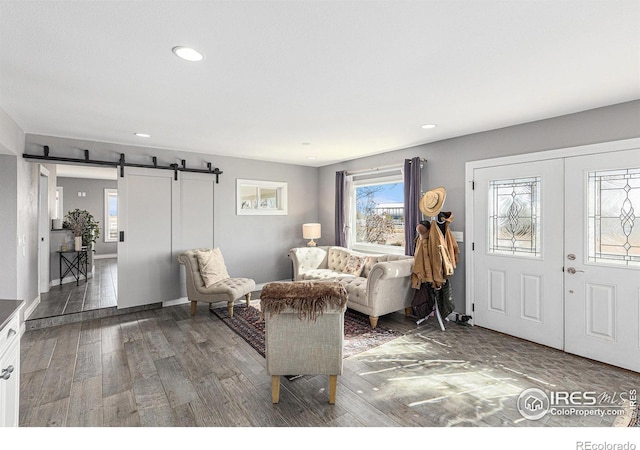 living room with recessed lighting, a barn door, wood finished floors, and french doors