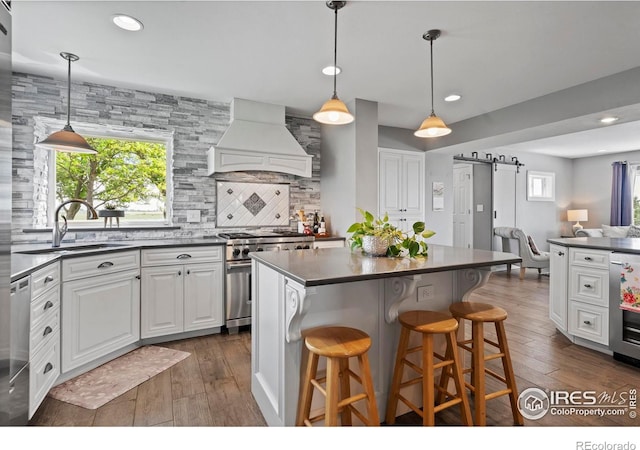 36340 County Road 49, Eaton, CO 80615 - kitchen featuring custom range hood, appliances with stainless steel finishes, dark countertops, decorative backsplash, and dark wood-type flooring
