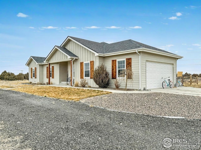 ranch-style house with an attached garage, a shingled roof, board and batten siding, and concrete driveway