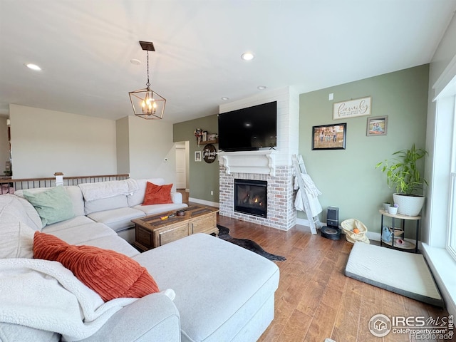 living room featuring a chandelier, recessed lighting, a fireplace, wood finished floors, and baseboards