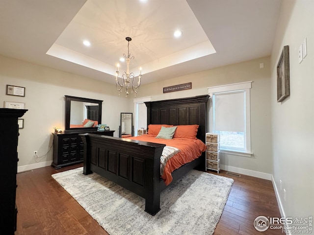 bedroom featuring dark wood-style floors, a raised ceiling, and baseboards