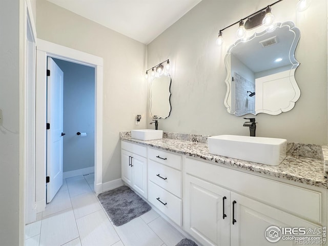 full bath with visible vents, a sink, baseboards, and double vanity