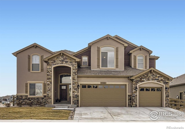 view of front of home featuring roof with shingles, concrete driveway, and stucco siding