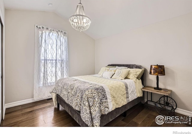 bedroom featuring vaulted ceiling, baseboards, wood finished floors, and a chandelier