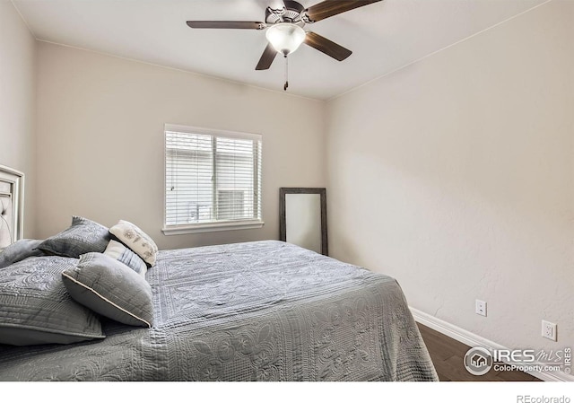 bedroom featuring a ceiling fan, baseboards, and wood finished floors