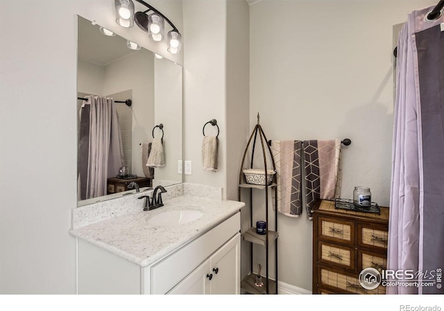 bathroom with curtained shower and vanity